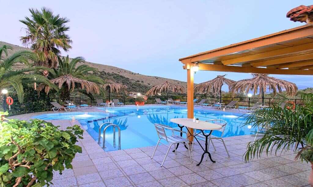 Poolside seating in the evening at Welcome Apts